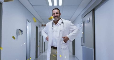 Smiling Doctor Celebrating in Hospital Corridor with Confetti