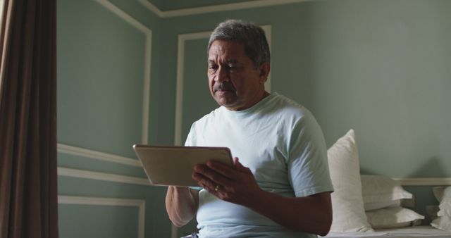 Senior Man Using Tablet While Sitting on Bed - Download Free Stock Images Pikwizard.com