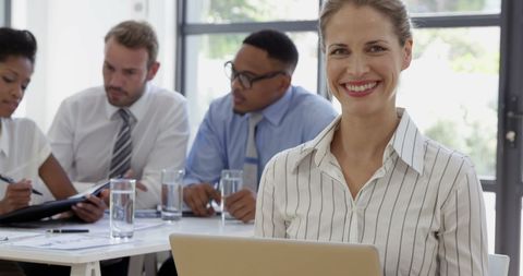 Confident Businesswoman Smiling with Laptop in Business Meeting - Download Free Stock Images Pikwizard.com