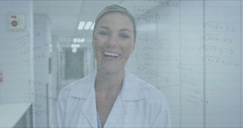 Smiling scientist with mathematical equations overlay in modern laboratory