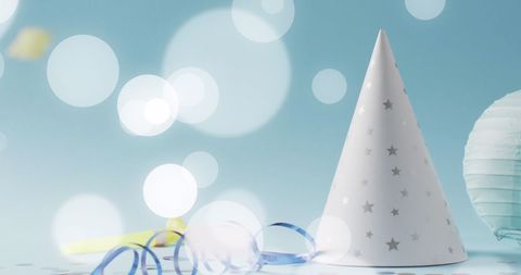 Festive party hat with streamers against blurred lights background