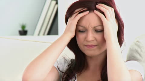Woman Experiencing Headache on Comfortable Sofa