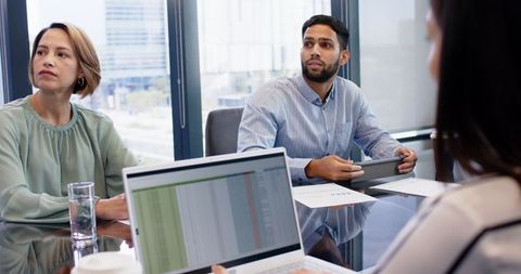 Business Meeting with Colleagues Engaged in Discussion and Technology