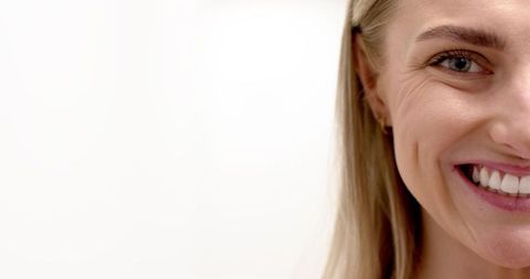 High-key close-up smiling blonde woman headshot with clean copy space for branding