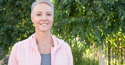 Senior Woman Embracing Nature in Sunlit Garden Setting