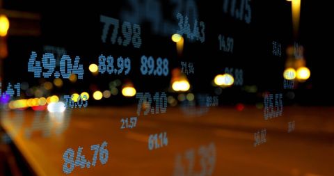 Financial Data Overlay on Busy City Street at Night