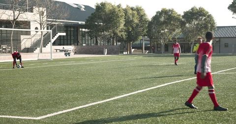 Soccer players training on sports field in colorful uniforms