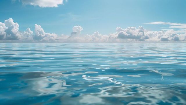 Serene Blue Ocean Under Puffy Clouds with Tranquil Waters