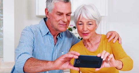 Senior Couple Engaging with Smartphone Together