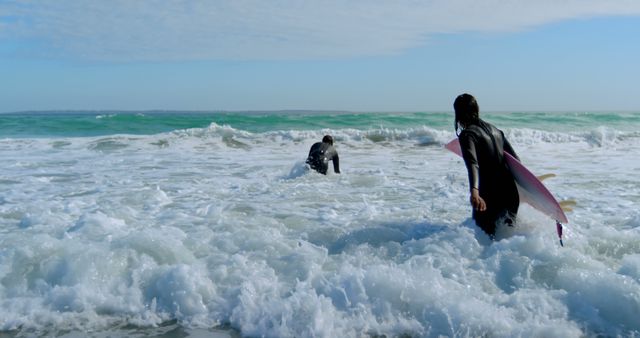 Surfers Entering Turbulent Ocean Waves Under Cloudy Sky - Download Free Stock Images Pikwizard.com