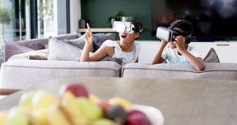 Excited siblings experiencing virtual reality adventure