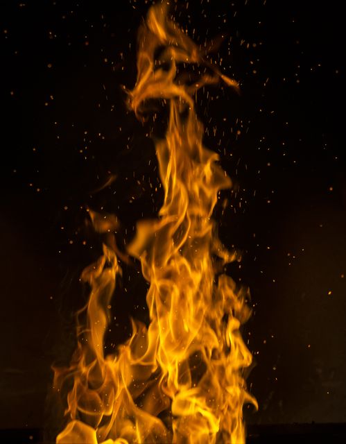 Intense Flame with Sparking Ember in Dark Background - Download Free Stock Photos Pikwizard.com