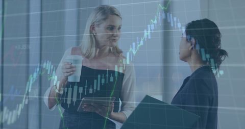Businesswomen Engaged in Financial Discussion with Stock Market Graph Overlay