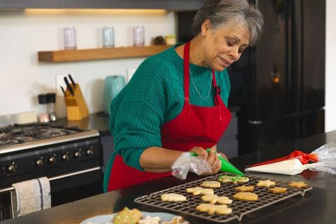 Senior Woman Competent in Cookie Decoration at Home Kitchen Counter