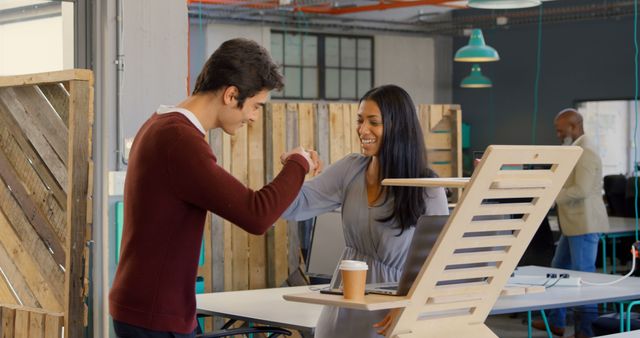 Friendly Office Greeting, Diverse Colleagues Fist Bumping in Modern Workspace - Download Free Stock Images Pikwizard.com