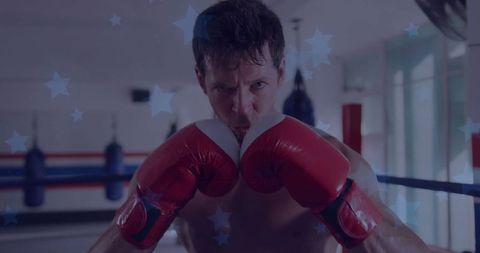 Male boxer defending with intensity in boxing gym