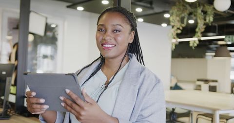 Confident African American Businesswoman with Tablet in Modern Office