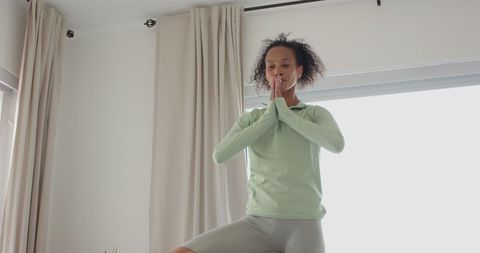 Woman Practicing Tree Pose in Sunlit Living Room