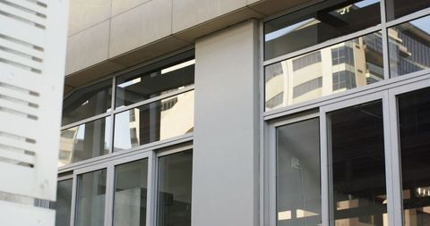 Modern glass facade reflecting curved office tower urban architectural detail