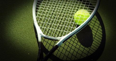 Tennis Racket and Ball on Green Court with Shadows
