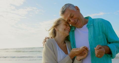 Joyful Senior Caucasian Couple Embracing on Sunlit Beach