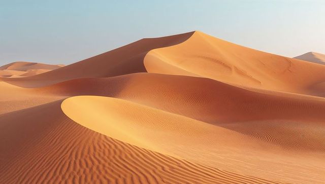 Golden sunlit sand dunes rolling across vast desert with ripple texture and long shadows