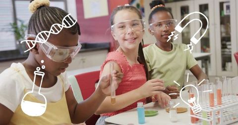 Multiracial girls conducting stem science experiment in school lab wearing safety goggles