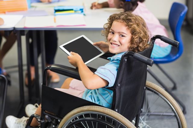 Smiling Disabled Schoolboy Using Tablet in Classroom - Download Free Stock Photos Pikwizard.com