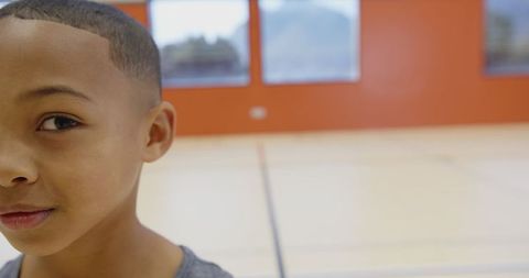 Boy Smiling Joyfully in School Gym Environment