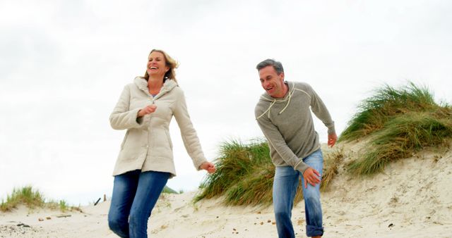 Happy Mature Couple Enjoying a Beach Walk - Download Free Stock Images Pikwizard.com