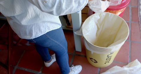 Eco-conscious Individual Disposing Plastic Waste Indoors