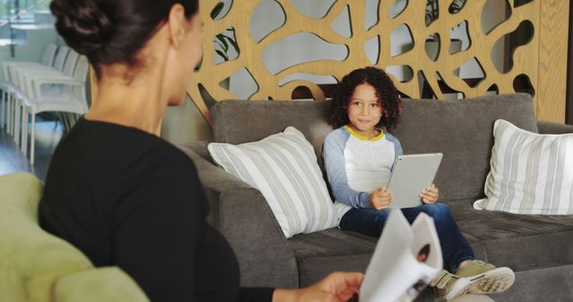 Mother and Child Sitting on Sofa with Tablet and Magazine - Download Free Stock Images Pikwizard.com