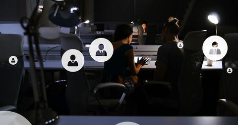 Business Professionals Discussing Data in Modern Office at Night