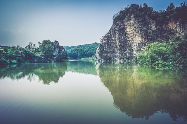 Serene Landscape of a Tranquil Lake with Rocky Cliffs - Download Free Stock Photos Pikwizard.com