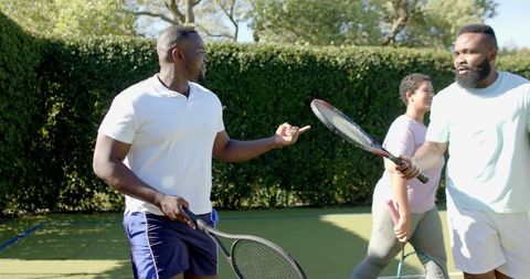 Diverse Friends Engaging in Lively Discussion on Tennis Court