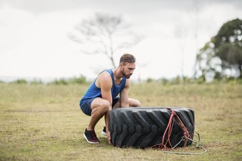 Athletic man preparing for outdoor tire flipping exercise