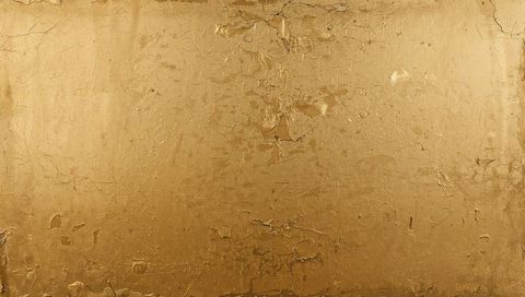 Textured distressed gold panel with peeling gilding and cracked plaster patina