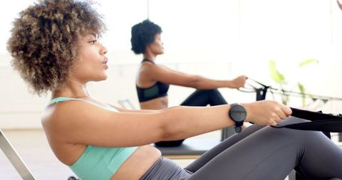 Women Practicing Pilates on Rowing Machines with Intense Focus - Download Free Stock Images Pikwizard.com