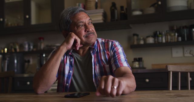 Pensive Senior Man Sitting at Kitchen Table Reflecting Thoughtfully - Download Free Stock Images Pikwizard.com