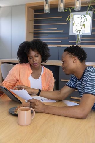 African american couple reviewing finances and planning future at modern kitchen table
