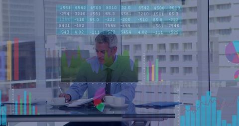 Executive reviewing financial data at glass desk writing with interactive charts overlay