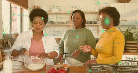 Three women mixing dough and preparing meal at kitchen island with digital data overlay