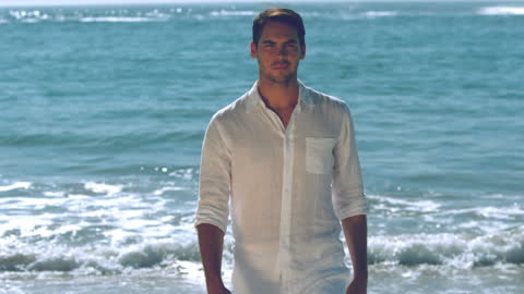 Man in White Strolling by Ocean during Sunny Day