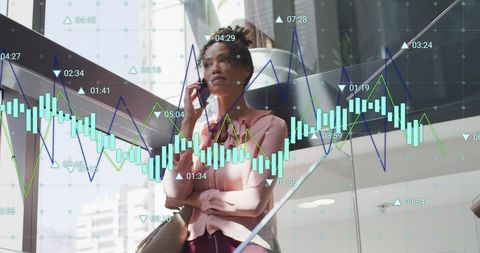 Businesswoman analyzing graphs while talking on cellphone