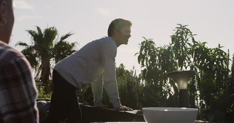 Man Relaxing on Rooftop Terrace with Palm Trees in Background