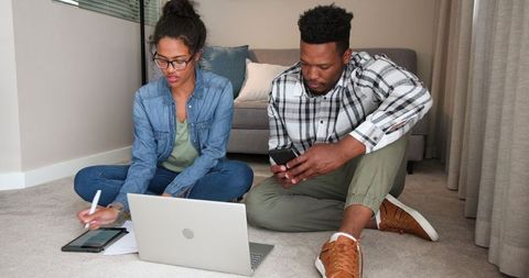 Couple Planning Finances at Home with Laptop and Documents