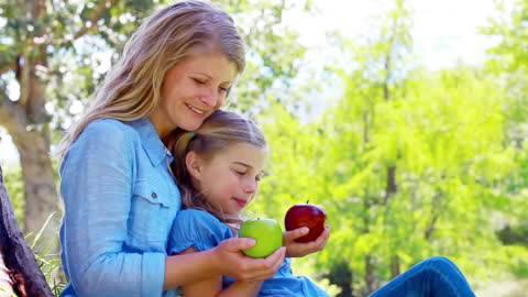 Mother and Daughter Enjoying Apples in Park