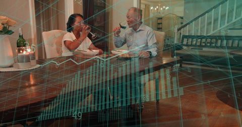 Mature couple sharing wine during intimate home dinner with financial graph overlay