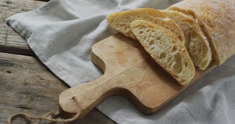 Fresh artisan bread on rustic wooden breadboard