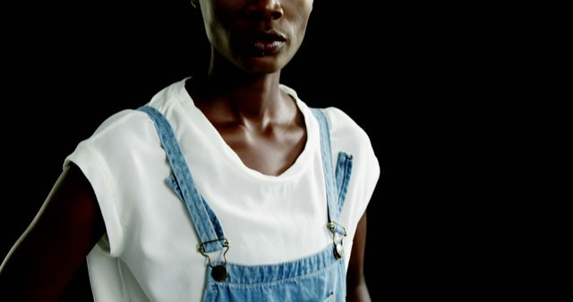 Confident Woman in Denim Overalls Posing Against Black Background - Download Free Stock Images Pikwizard.com